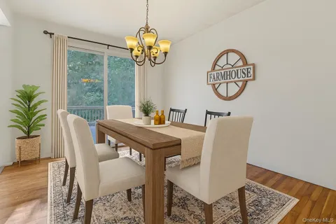 a view of a dining room with furniture a chandelier and wooden floor