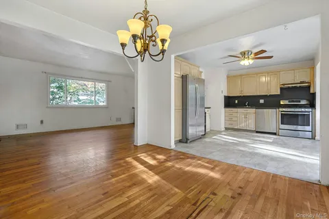 a view of a kitchen with granite countertop stainless steel appliances stove and a chandelier