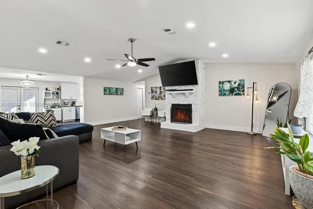 a living room with furniture a fireplace and a flat screen tv