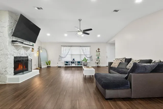 a living room with furniture a fireplace and a flat screen tv