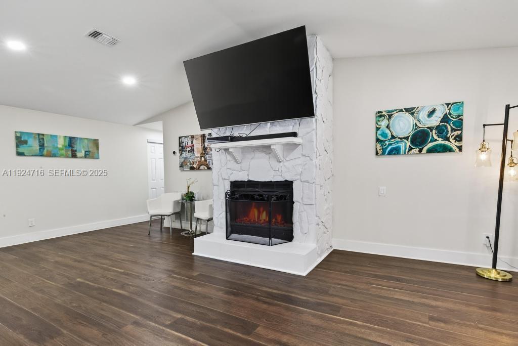 8210 Sailmaker Lane Jacksonville, FL 32210 - Photo 23 of 61 a living room with furniture a fireplace and a flat screen tv