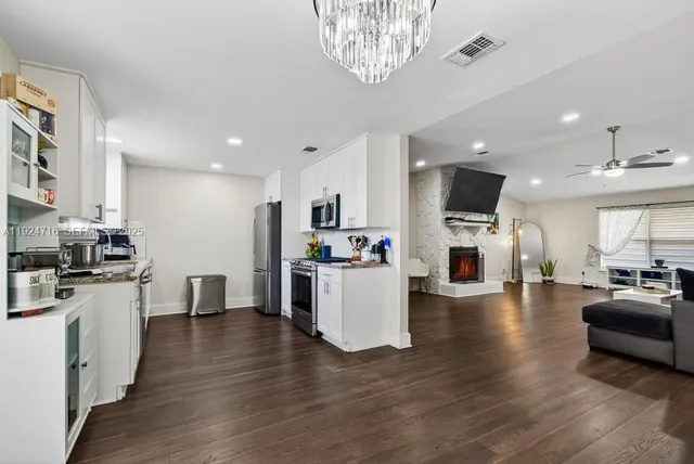 a kitchen with stainless steel appliances granite countertop a stove a sink and a refrigerator