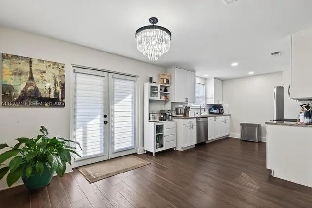 a kitchen with granite countertop white cabinets and a sink