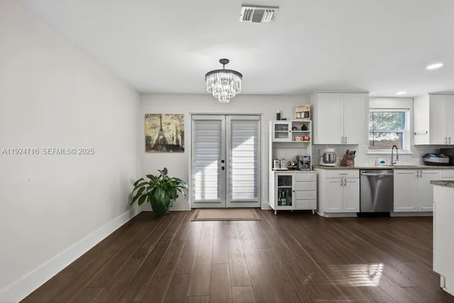 a kitchen with stainless steel appliances granite countertop a stove a refrigerator a microwave a sink and white cabinets