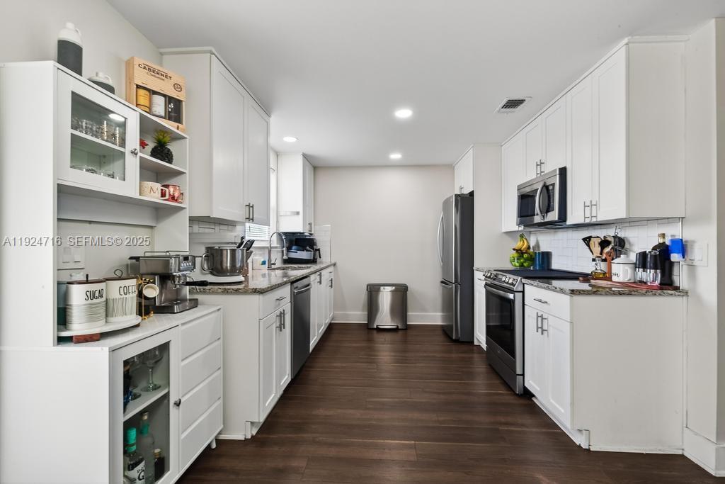 8210 Sailmaker Lane Jacksonville, FL 32210 - Photo 34 of 61 a kitchen with stainless steel appliances granite countertop a stove top oven a sink dishwasher and a refrigerator