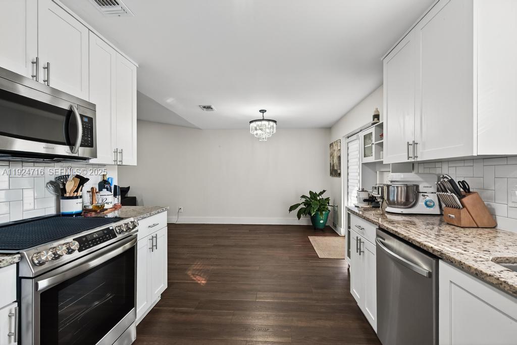 8210 Sailmaker Lane Jacksonville, FL 32210 - Photo 35 of 61 a kitchen with granite countertop cabinets stainless steel appliances and wooden floor