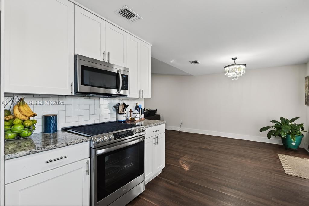 8210 Sailmaker Lane Jacksonville, FL 32210 - Photo 36 of 61 a kitchen with stainless steel appliances white cabinets and a stove top oven