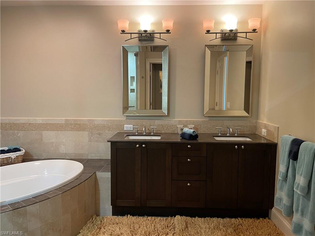 9115 Strada Place, Unit 5417 Naples, FL 34108 - Photo 13 of 21 a bathroom with a sink and a mirror