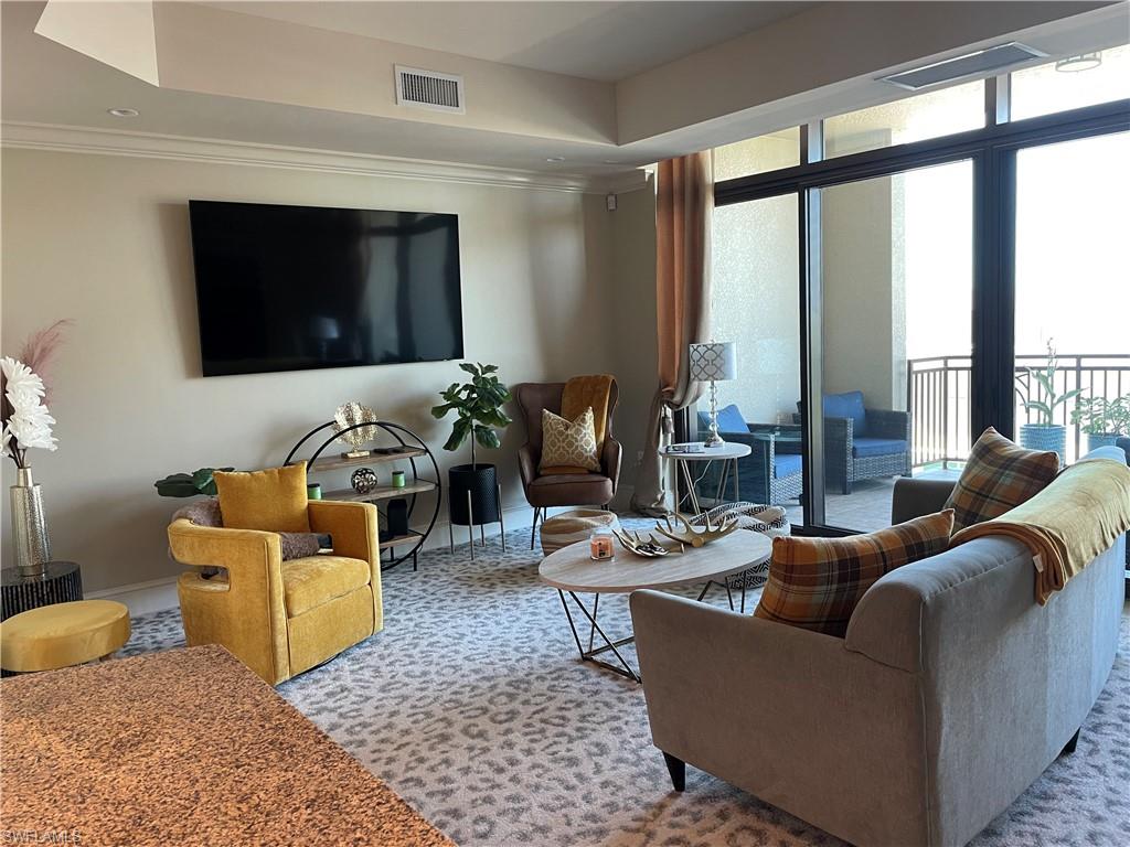 9115 Strada Place, Unit 5417 Naples, FL 34108 - Photo 5 of 21 a living room with furniture and a flat screen tv