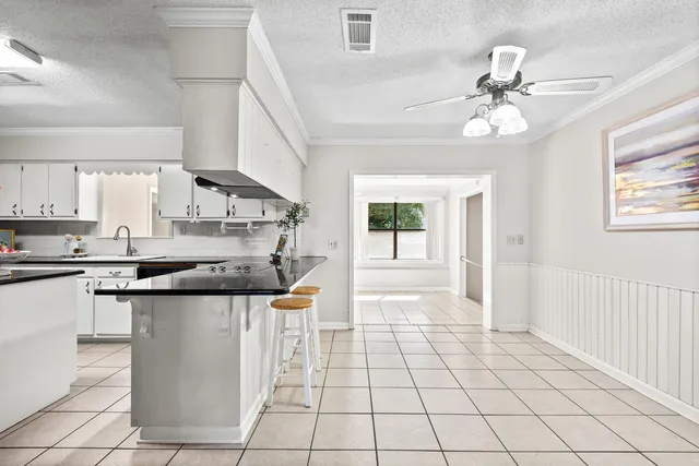 a kitchen with granite countertop white cabinets and white appliances