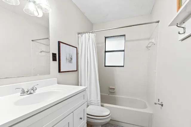 a backyard of a house with large trees and outdoor seating