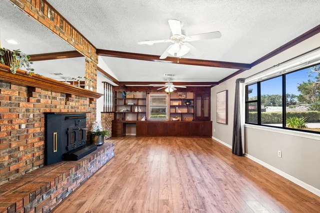 a view of empty room with wooden floor and fireplace
