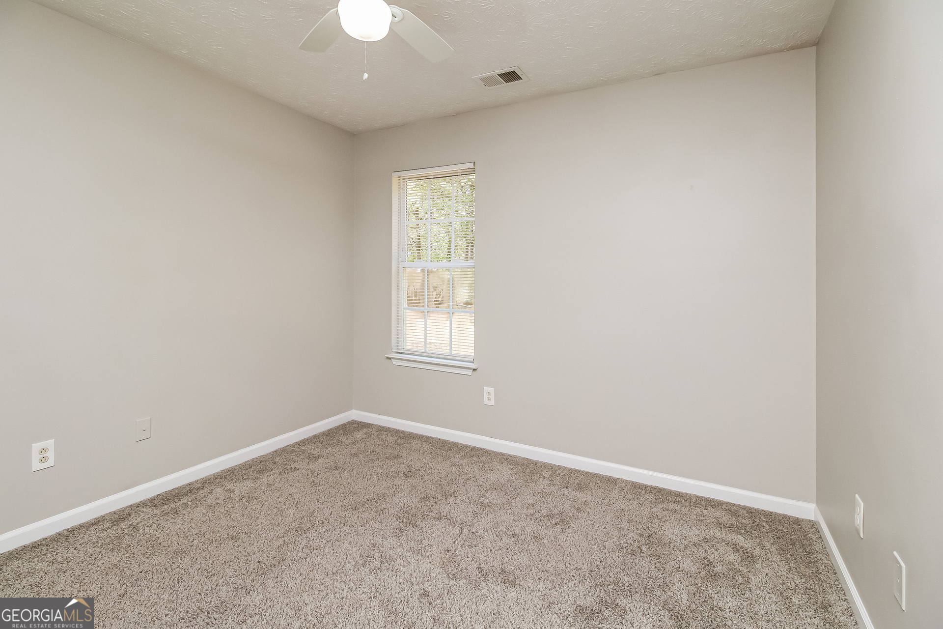 460 Mountainview Drive Covington, GA 30016 - Photo 12 of 15 an empty room with a window and a chandelier fan
