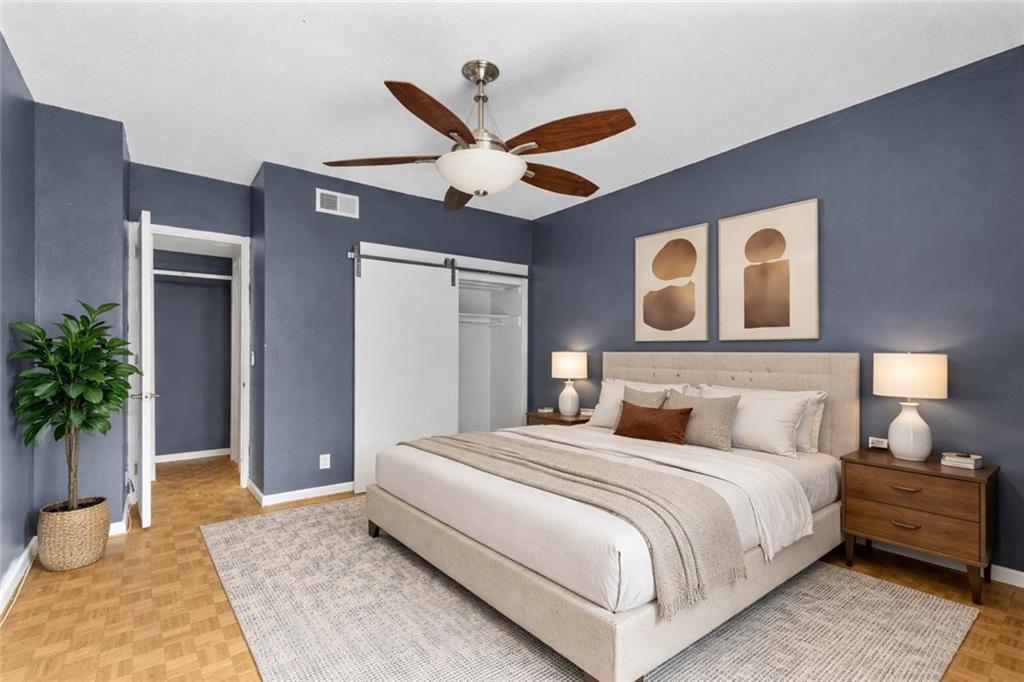 130 26th Street Northwest, Unit 307 Atlanta, GA 30309 - Photo 5 of 12 a bedroom with a large bed and a potted plant