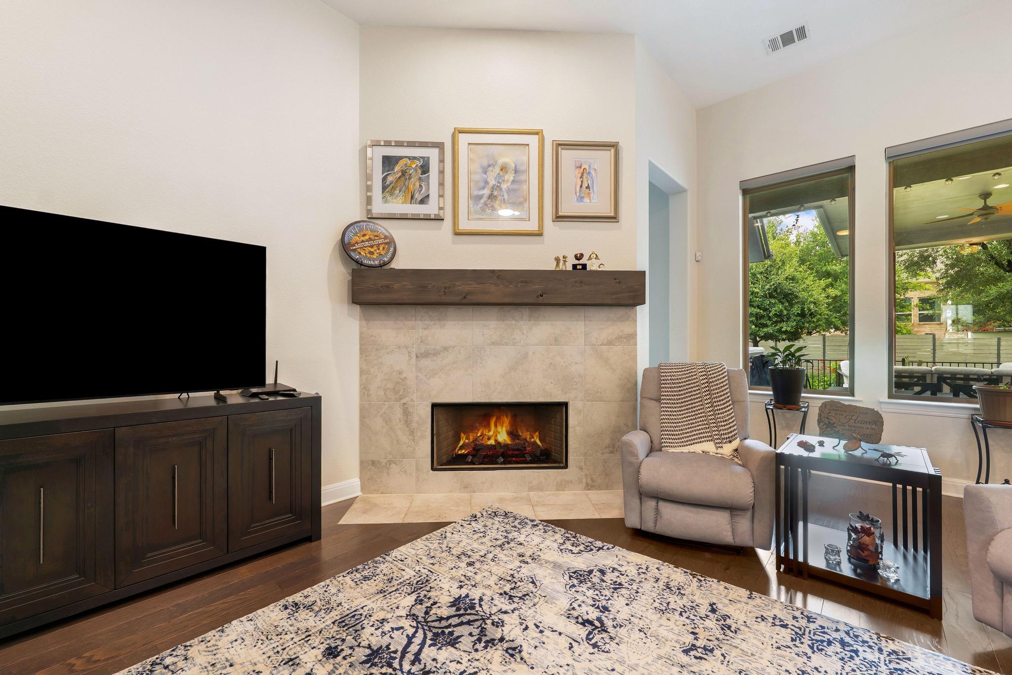 1009 Legacy Crossing Georgetown, TX 78628 - Photo 12 of 40 A cozy living space features a warm fireplace and rich hardwood flooring, inviting relaxation.