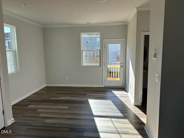a view of a hallway with wooden floor and a chair