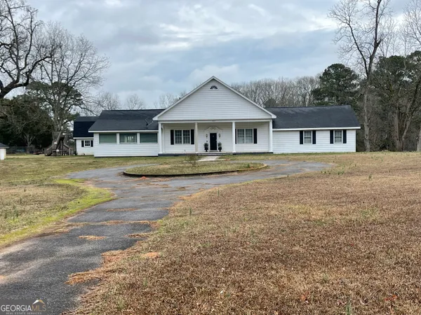 a front view of a house with a yard and trees