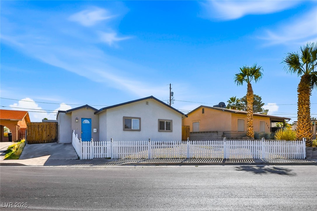 View of front of house featuring stucco siding and a fenced front yard