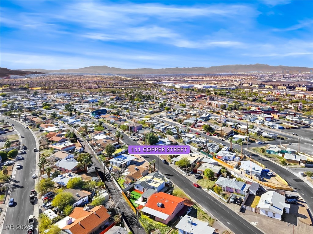 111 Copper Street Henderson, NV 89015 - Photo 21 of 47 Aerial view of property and surrounding area featuring a mountain backdrop and nearby suburban area