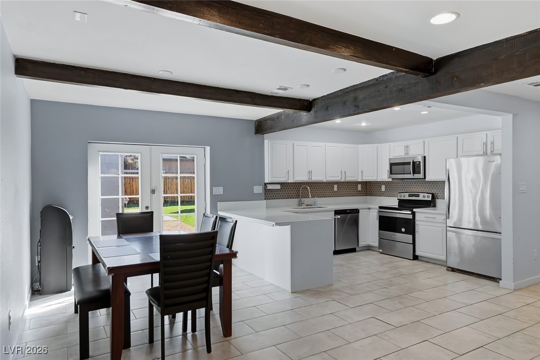 111 Copper Street Henderson, NV 89015 - Photo 35 of 47 Kitchen with french doors, light countertops, stainless steel appliances, white cabinetry, and tasteful backsplash