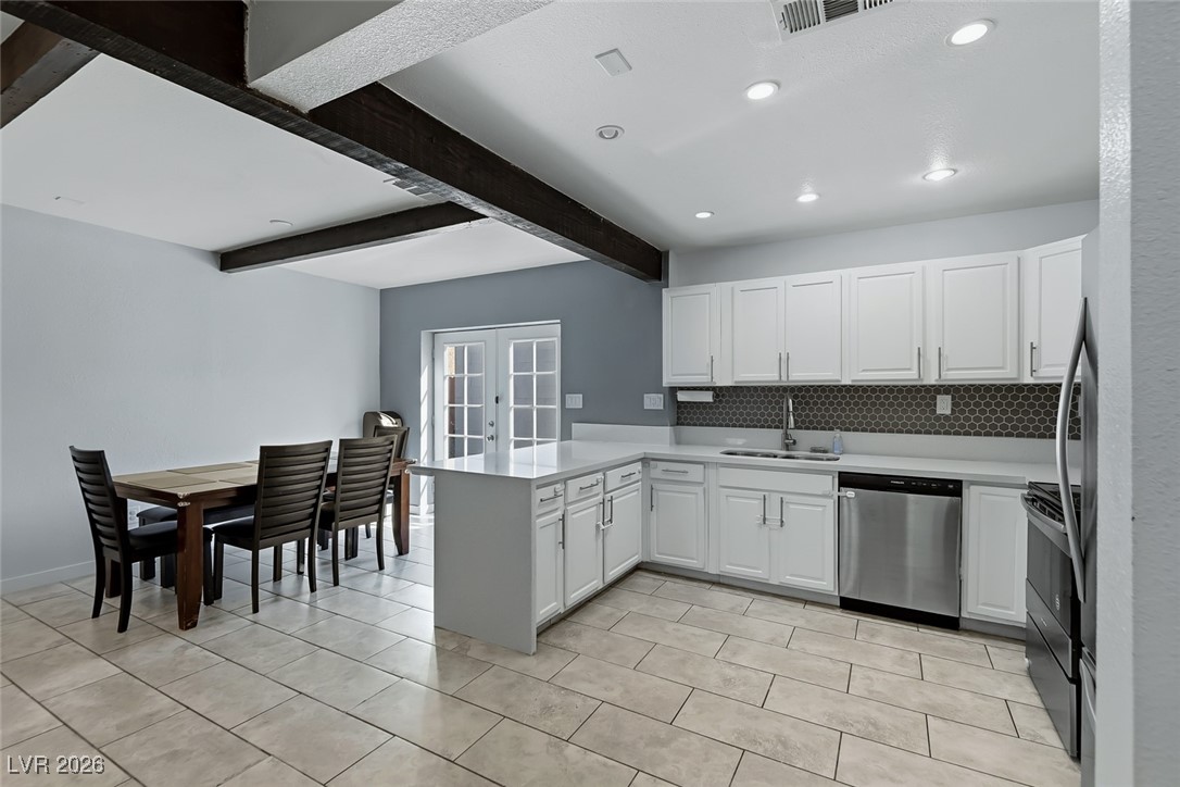 111 Copper Street Henderson, NV 89015 - Photo 38 of 47 Kitchen with white cabinets, stainless steel appliances, french doors, a peninsula, and beam ceiling