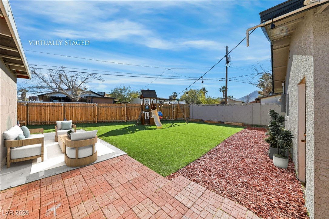111 Copper Street Henderson, NV 89015 - Photo 5 of 47 Fenced backyard with a playground, outdoor furniture, and a patio area