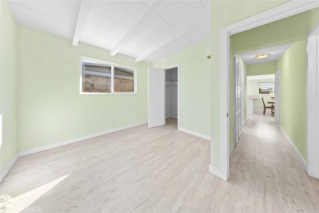 an empty room with wooden floor and a bathroom