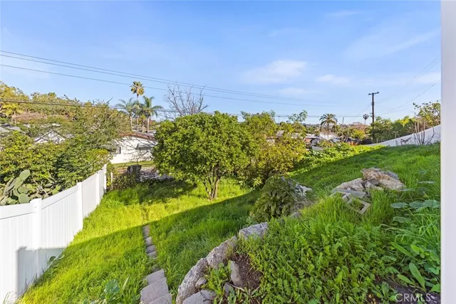 a view of a pathway both side of grassy field with shrub