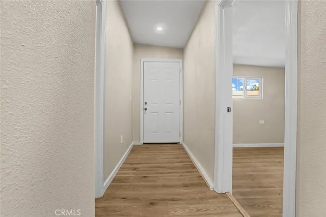 a view of a hallway with wooden floor