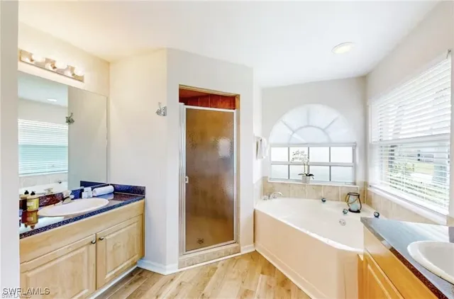 a spacious bathroom with a tub sink and mirror