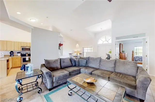 a living room with furniture and kitchen view