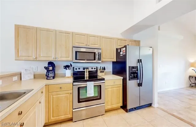 a kitchen with stainless steel appliances granite countertop a refrigerator stove and sink