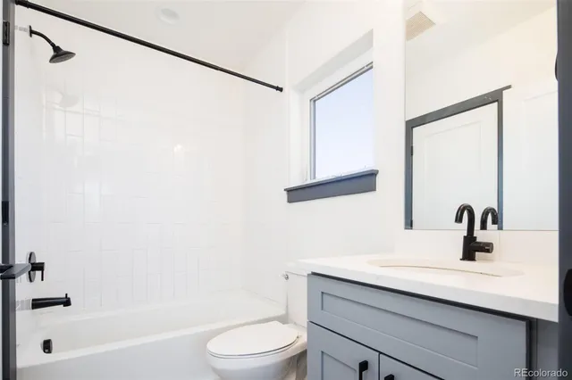 a bathroom with a sink a mirror a toilet and a bathtub