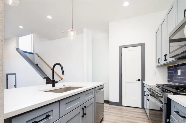 a kitchen with a sink stainless steel appliances and cabinets