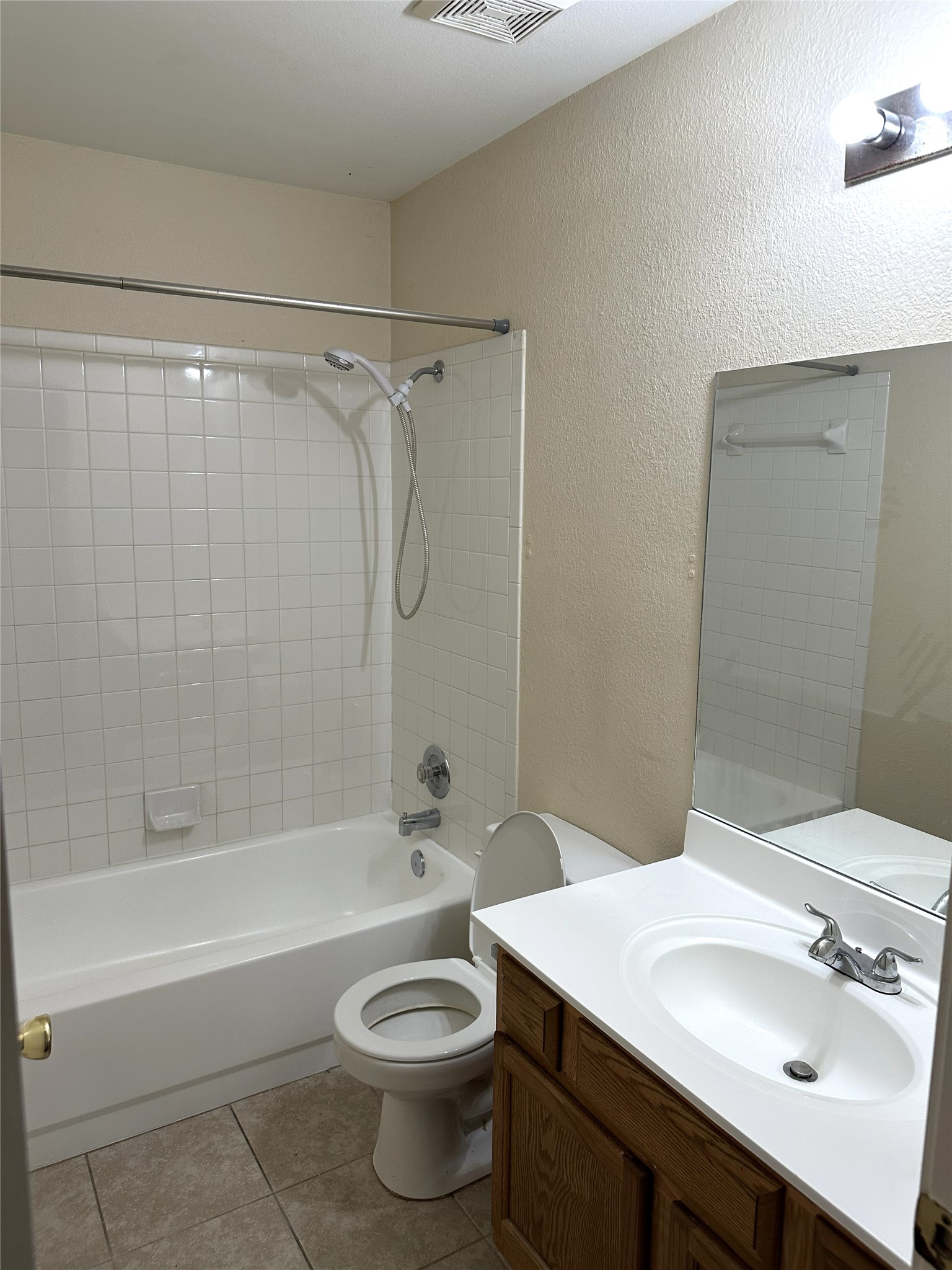 13915 Randalstone Drive Pflugerville, TX 78660 - Photo 16 of 19 Full bath with shower combination, vanity, a textured wall, and light tile patterned floors