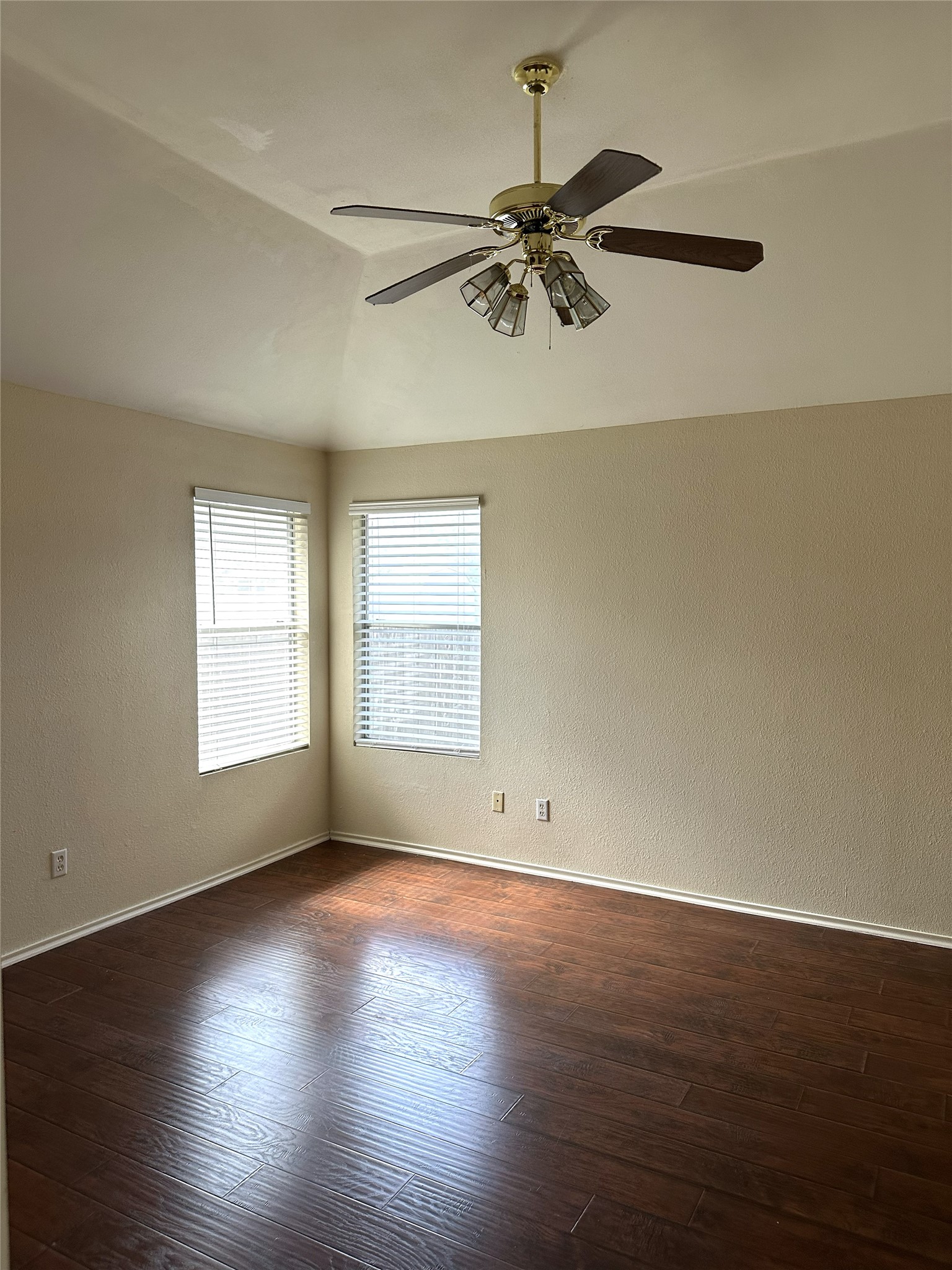 13915 Randalstone Drive Pflugerville, TX 78660 - Photo 10 of 19 Unfurnished room featuring a textured wall, dark wood finished floors, ceiling fan, and vaulted ceiling