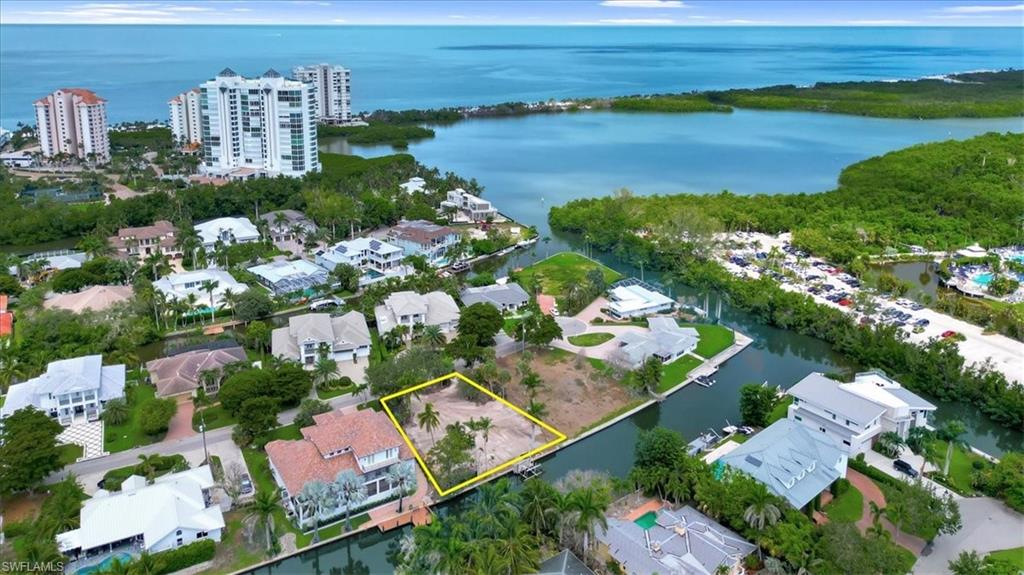 5186 Seashell Avenue Naples, FL 34103 - Photo 1 of 8 an aerial view of a city with lots of residential buildings ocean and mountain view in back