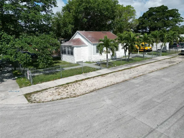 a view of a house with a yard and large trees