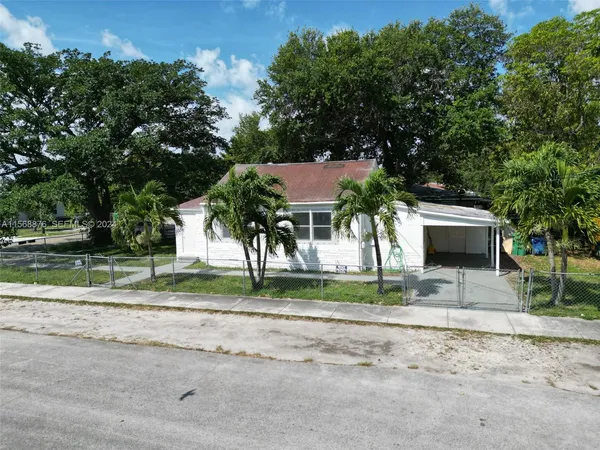a view of a house with a yard and large tree