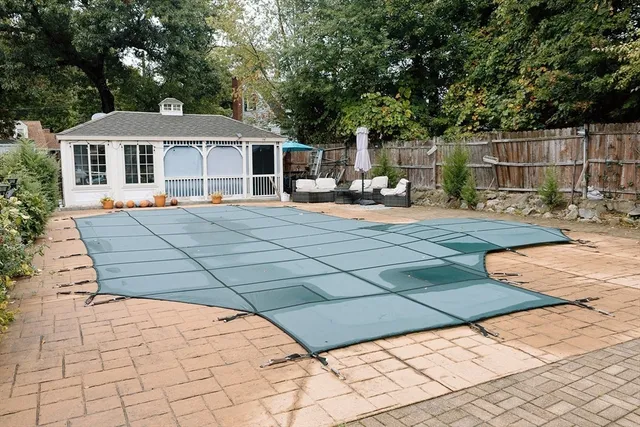 a front view of house with yard outdoor seating and covered with trees