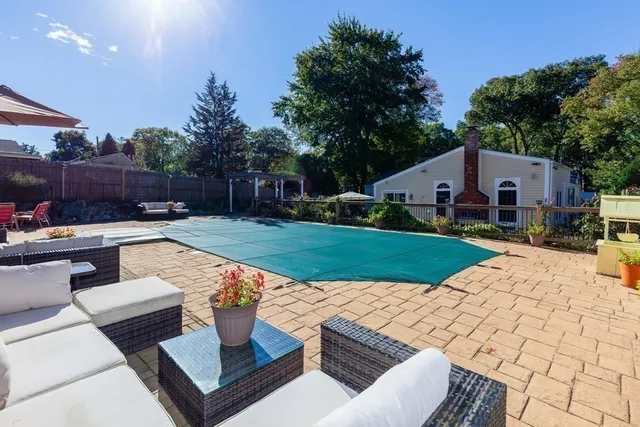 a view of a patio with couches table and chairs with wooden fence and plants