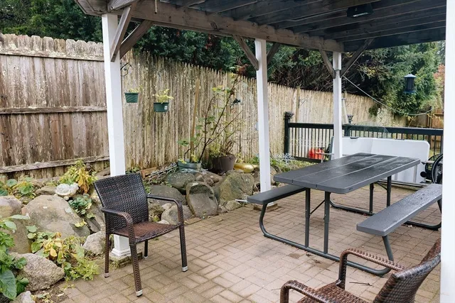 a view of a chairs and table in patio with wooden fence