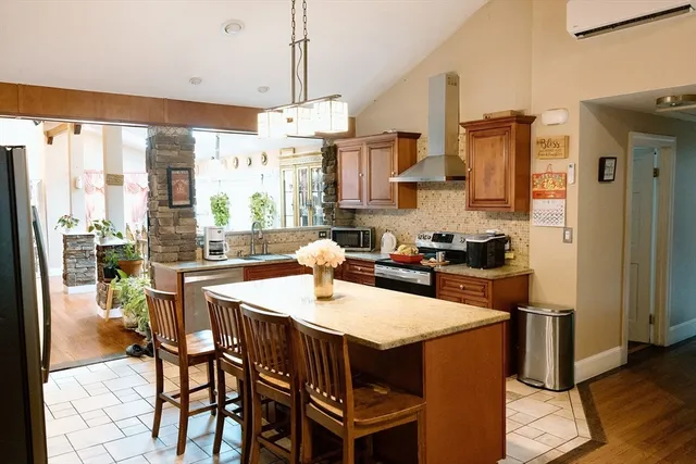 a kitchen with stainless steel appliances a dining table chairs and a refrigerator