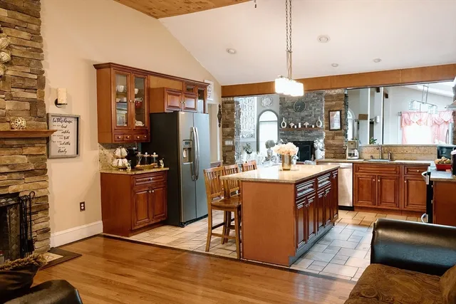 a kitchen with stainless steel appliances granite countertop a refrigerator a stove top oven a sink and dishwasher