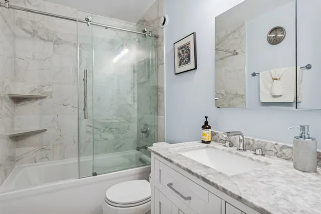 a bathroom with a granite countertop sink toilet and shower