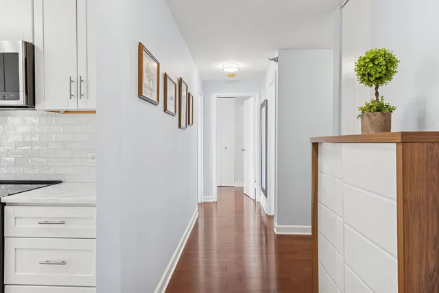 a view of a hallway with wooden floor and staircase