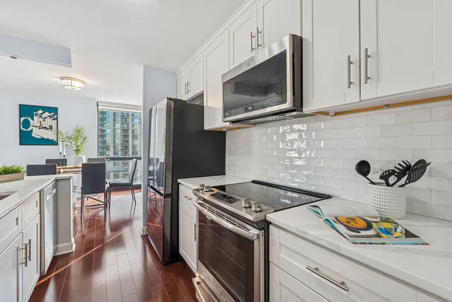 a kitchen with stainless steel appliances a stove microwave and refrigerator