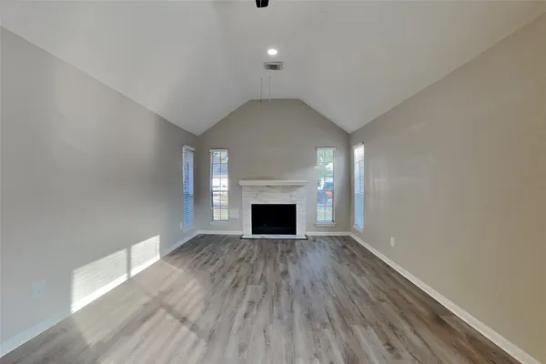 a view of a room wooden floor and fireplace