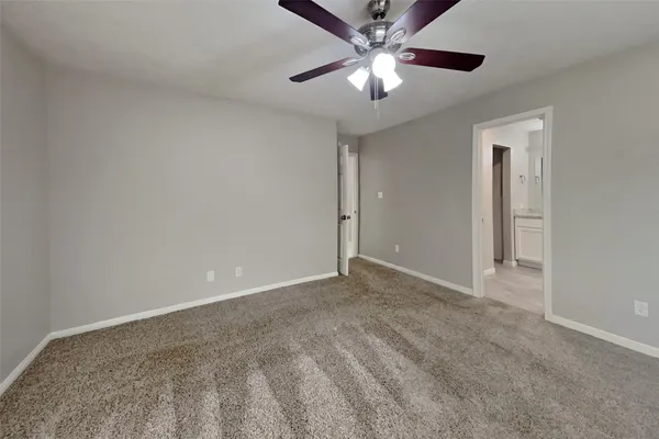 an empty room with chandelier fan