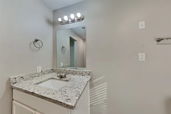 a bathroom with a granite countertop sink and a mirror